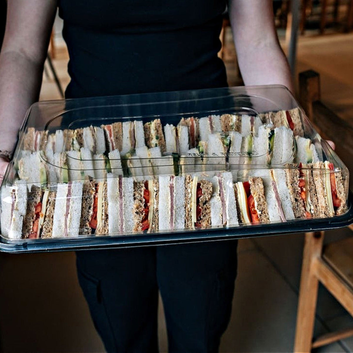 Set of 30 medium black buffet platters with clear lids by Platterplus, ideal for serving and presenting food at events.
